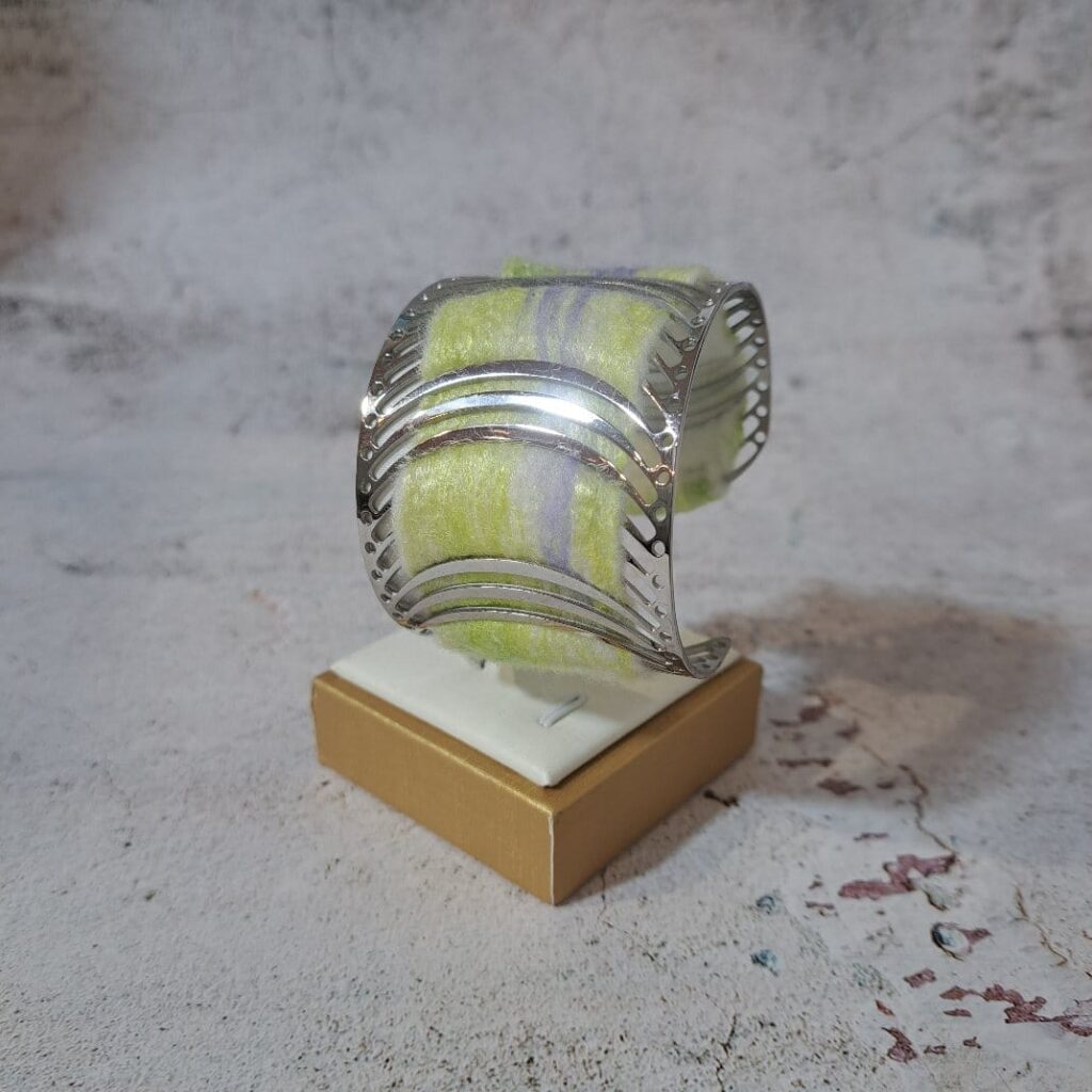 Brazalete amarillo, realizado en acero, lana y seda Brazalete de acero